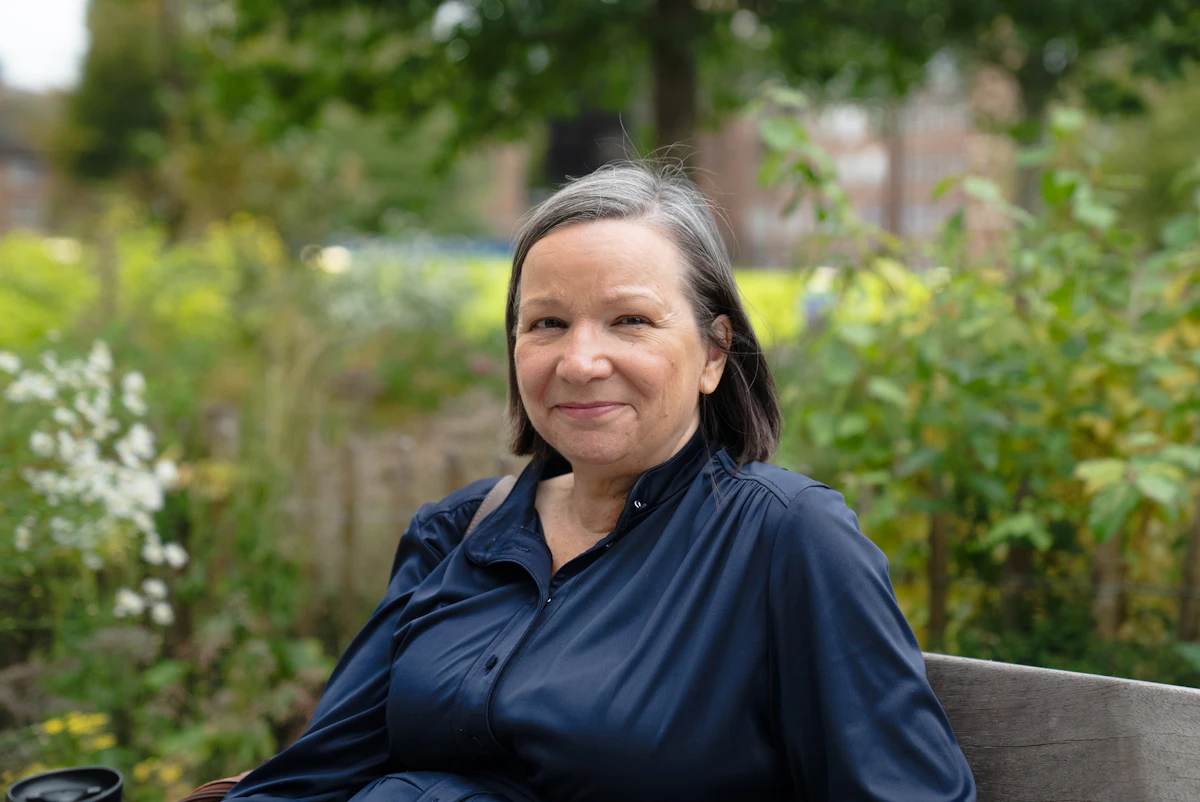 A woman smiles in a park setting