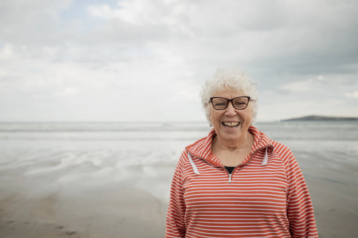Happy woman smiles at the beach with an ocean background