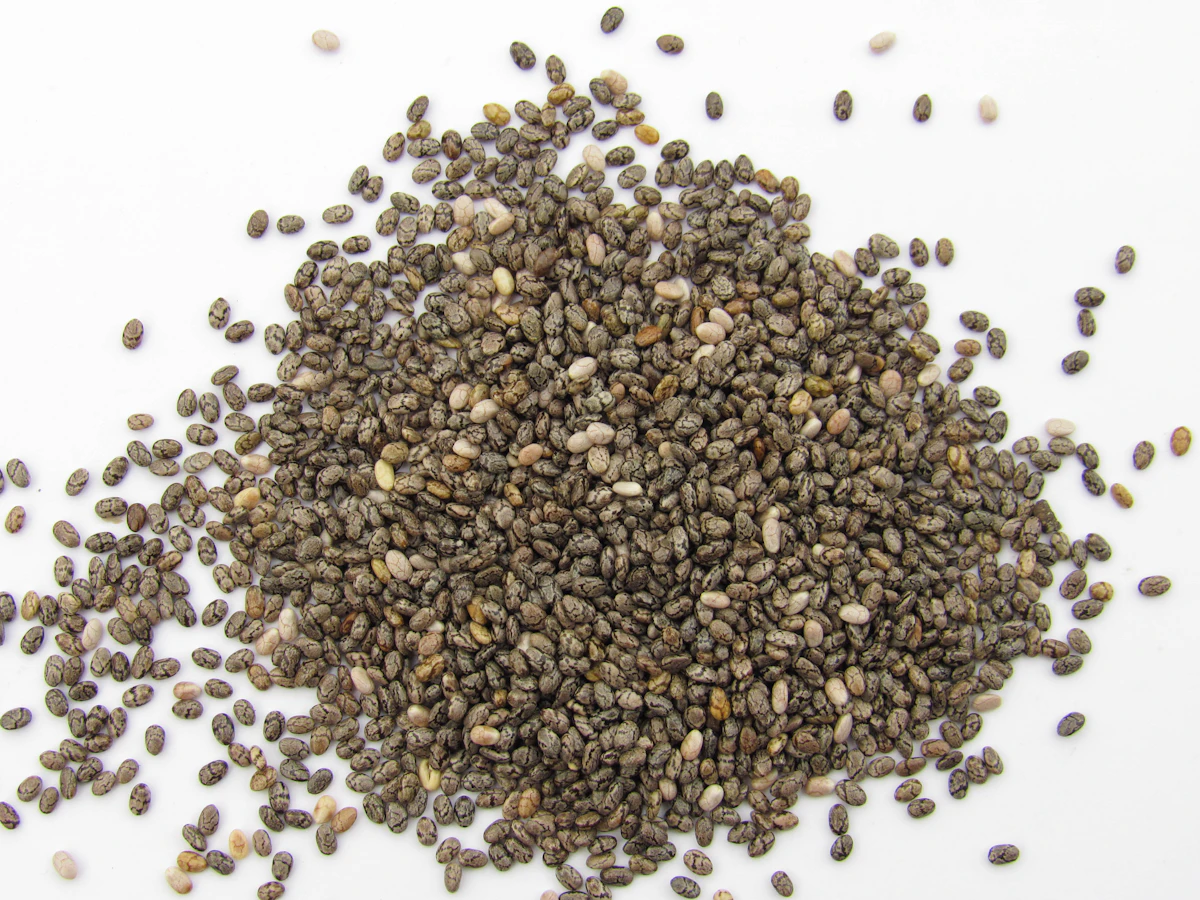 A pile of chia seeds on a white surface