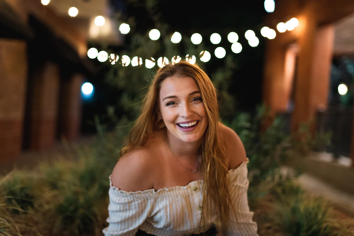 Woman in a white off-shoulder dress smiling