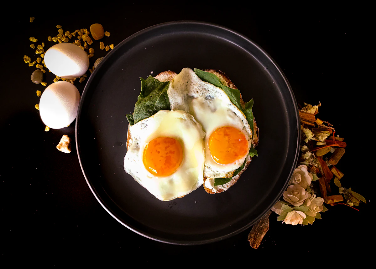 Sunny side up eggs on a black ceramic plate