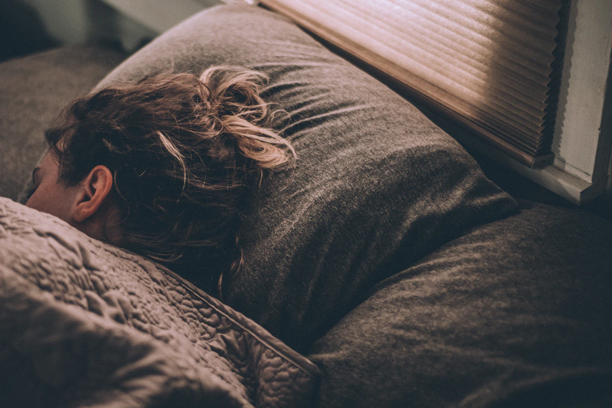 Woman sleeping on a bed under blankets
