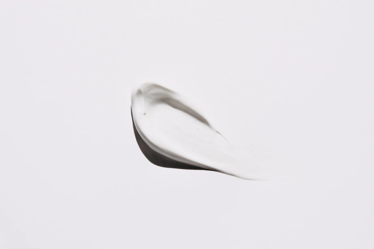 A smear of white cosmetic cream on a plain white background