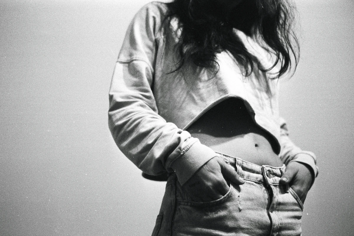 A black and white photo of a woman holding her stomach