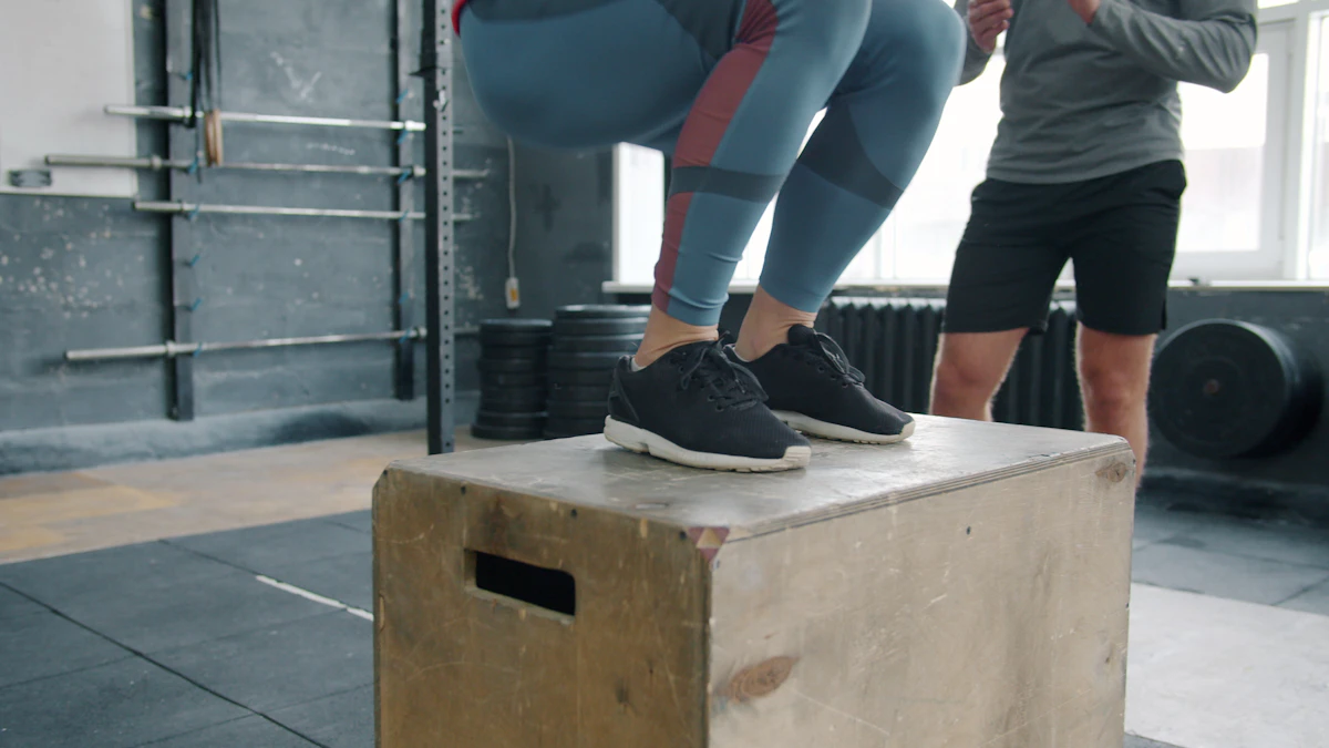 Woman jumping onto a wooden box in a gym