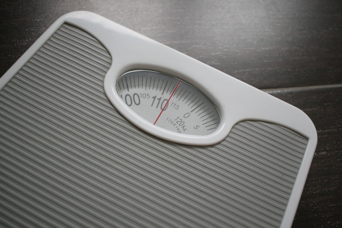 A bathroom scale on a wooden floor